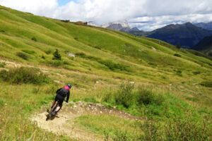 een mountainbiker rijdt een flow trail van het fassa bike park op de passo pordoi tijdens de mtb huttentocht dolomieten